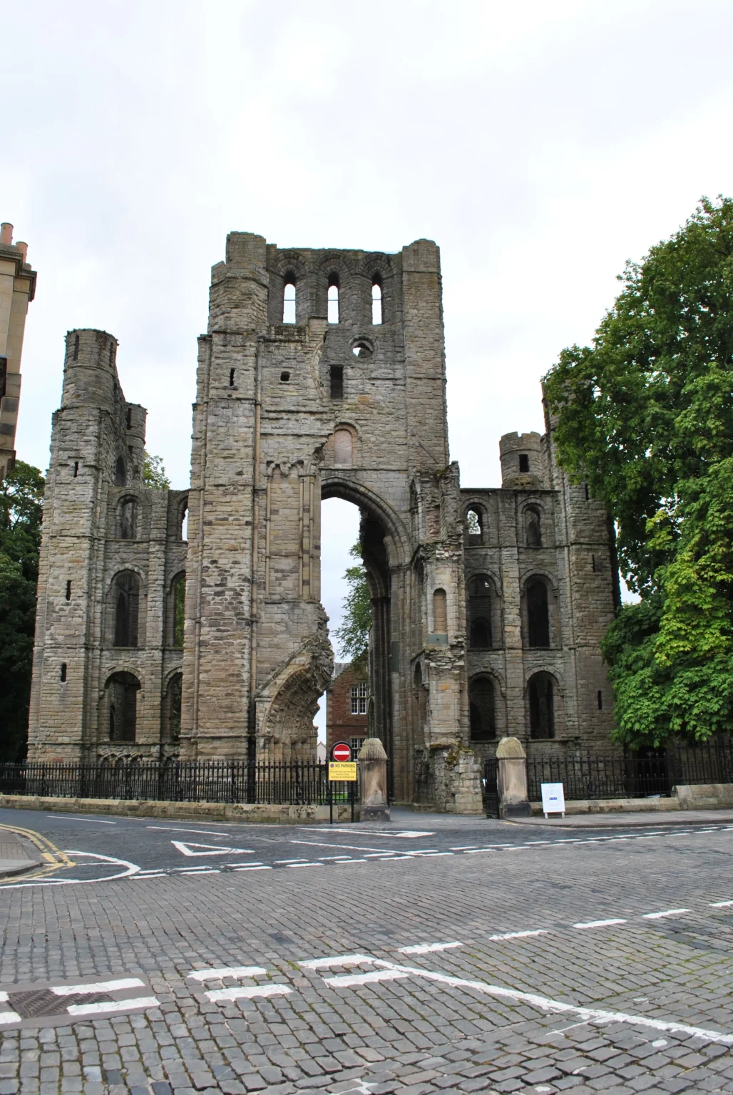 The ruined west front of a medieval abbey church in southern Scotland