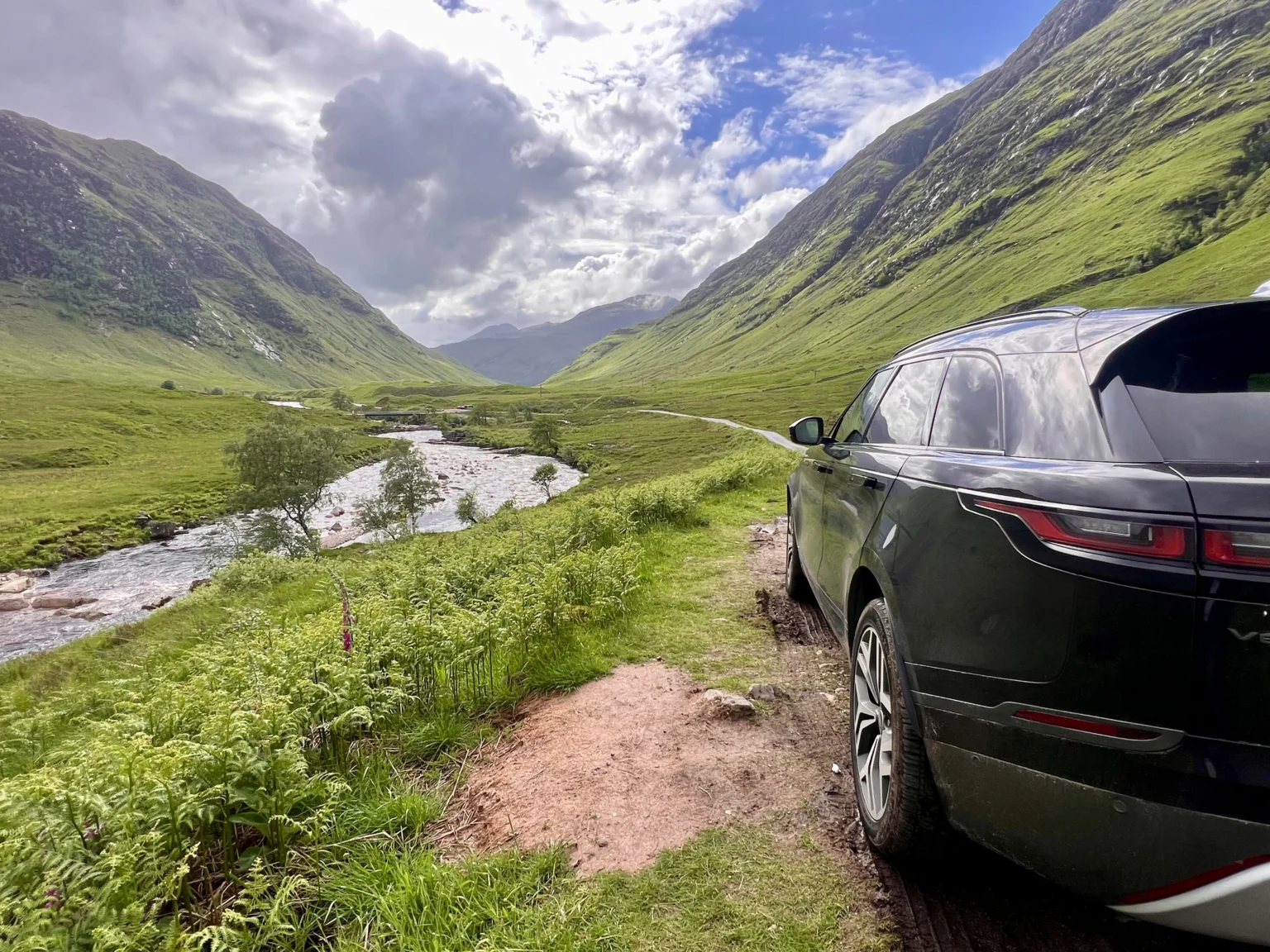 Tycoon Tours' private Range Rover beside a Highland river on a guided tour of Scotland