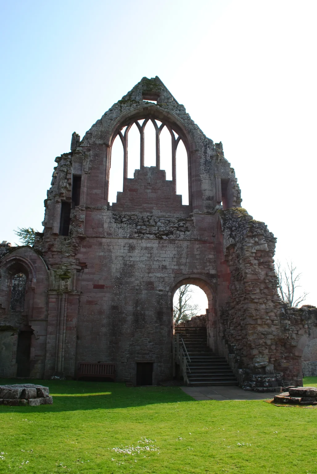 A ruined medieval abbey with a tall gable window, southern Scotland