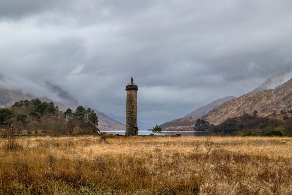 The Glenfinnan Monument tower standing in the misty glen at the head of Loch Shiel